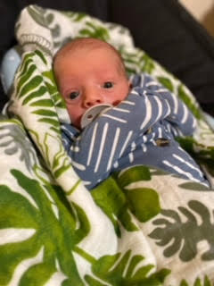 Baby Nash wrapped in his forest muslin swaddle.