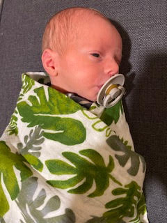 Baby Nash wrapped in his forest muslin swaddle. 